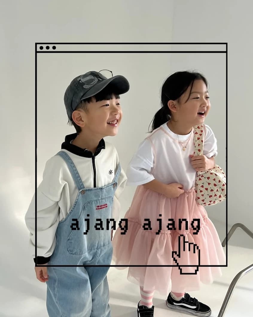 멜빵바지와 분홍 치마를 입고 나란히 웃는 두 아이