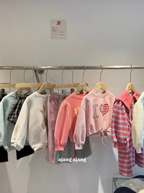 행거에 걸린 아이 상의와 니트
